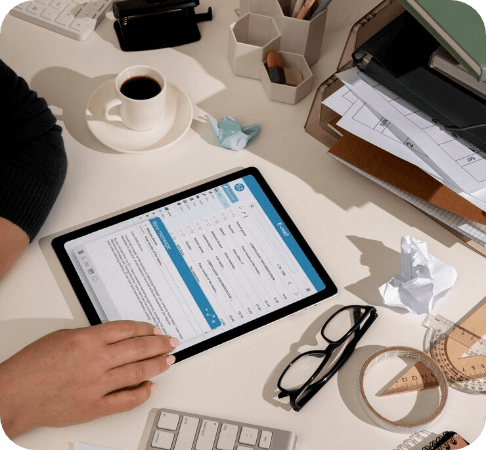 Healthcare professional examining billing paperwork and computer data.